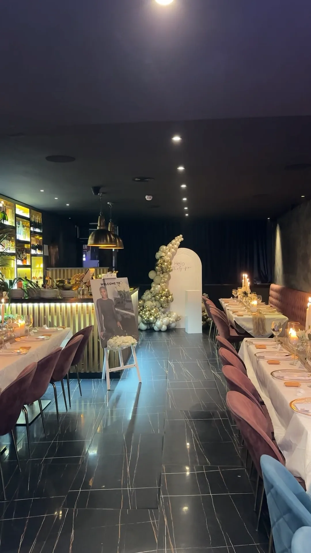 Birthday dinner setup with gold balloon arch and candlelit tables styled by LA' LUXE Events